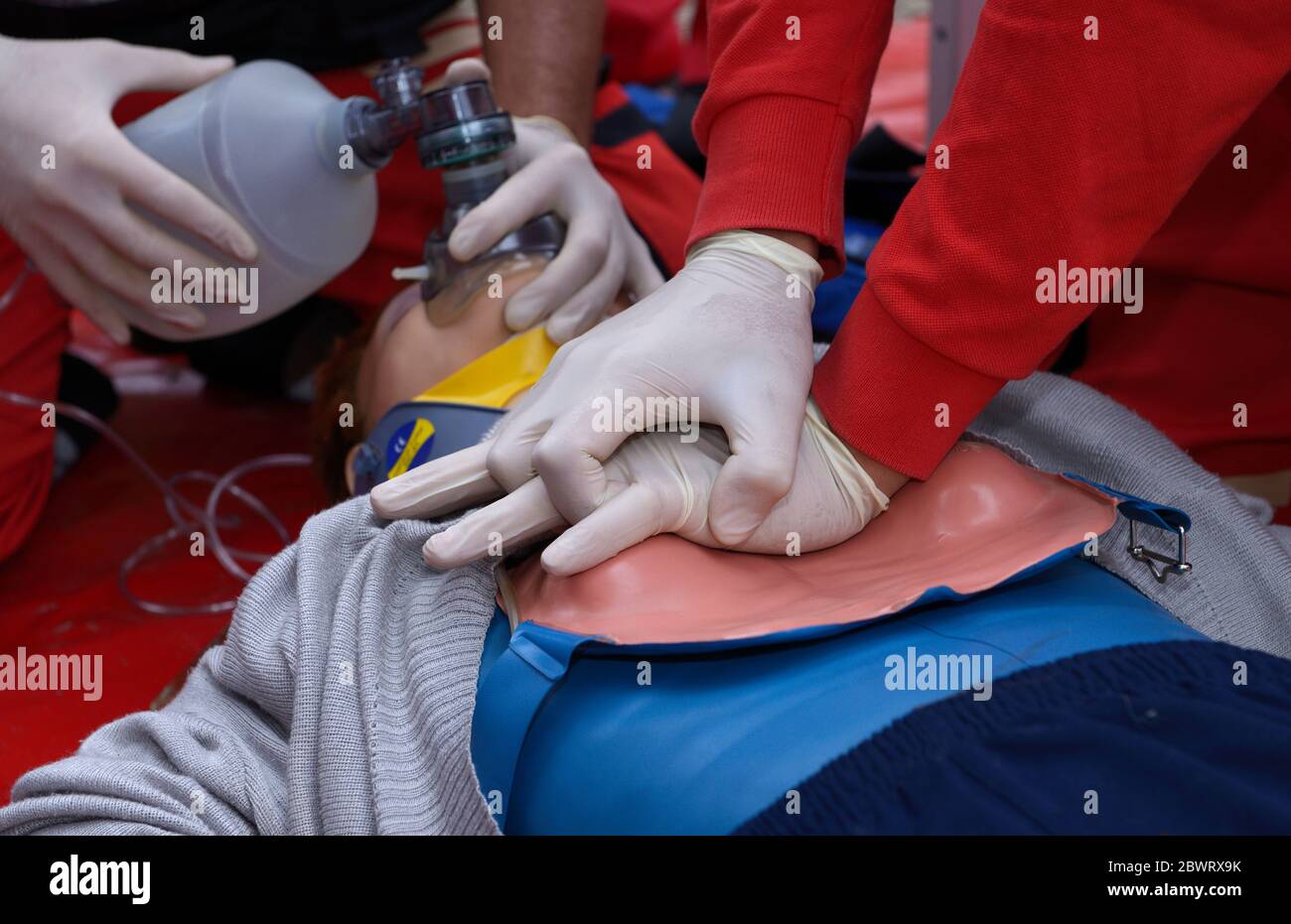Nothelfer drückt auf die Brust eines Patienten und hält ein Sauerstoffkissen auf seinem Gesicht. Künstliche Beatmung Stockfoto