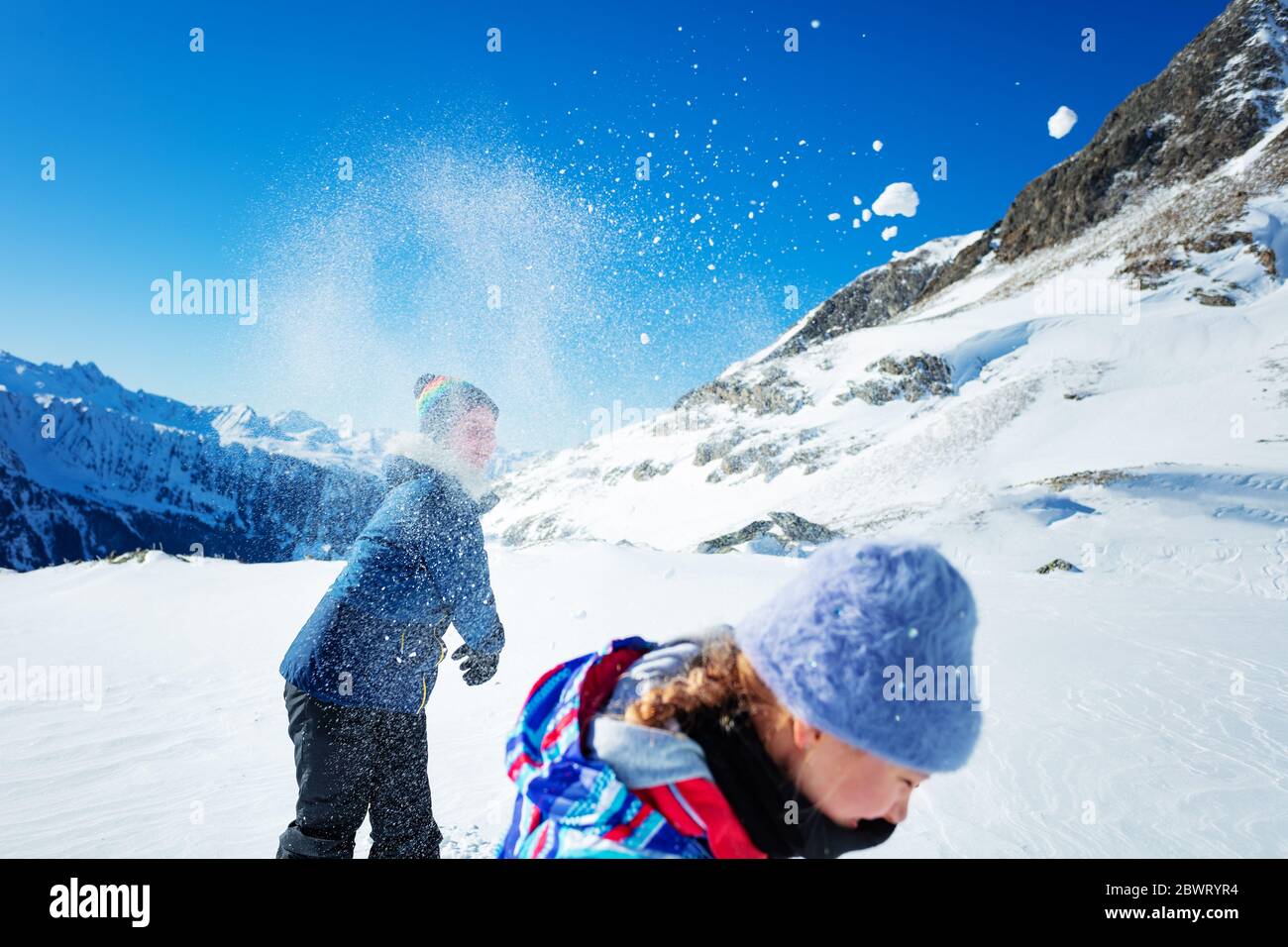 Spaß mit Schneeball Mädchen wirft auf einen anderen Schnee Ply Action Winter Spiel in den Bergen Stockfoto