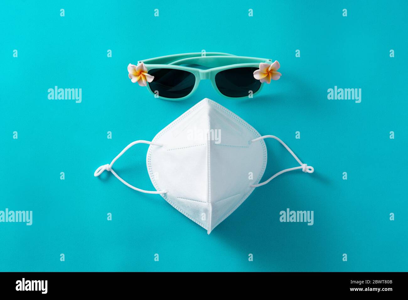 Sonnenbrille und Schutzmaske auf blauem Hintergrund Stockfoto