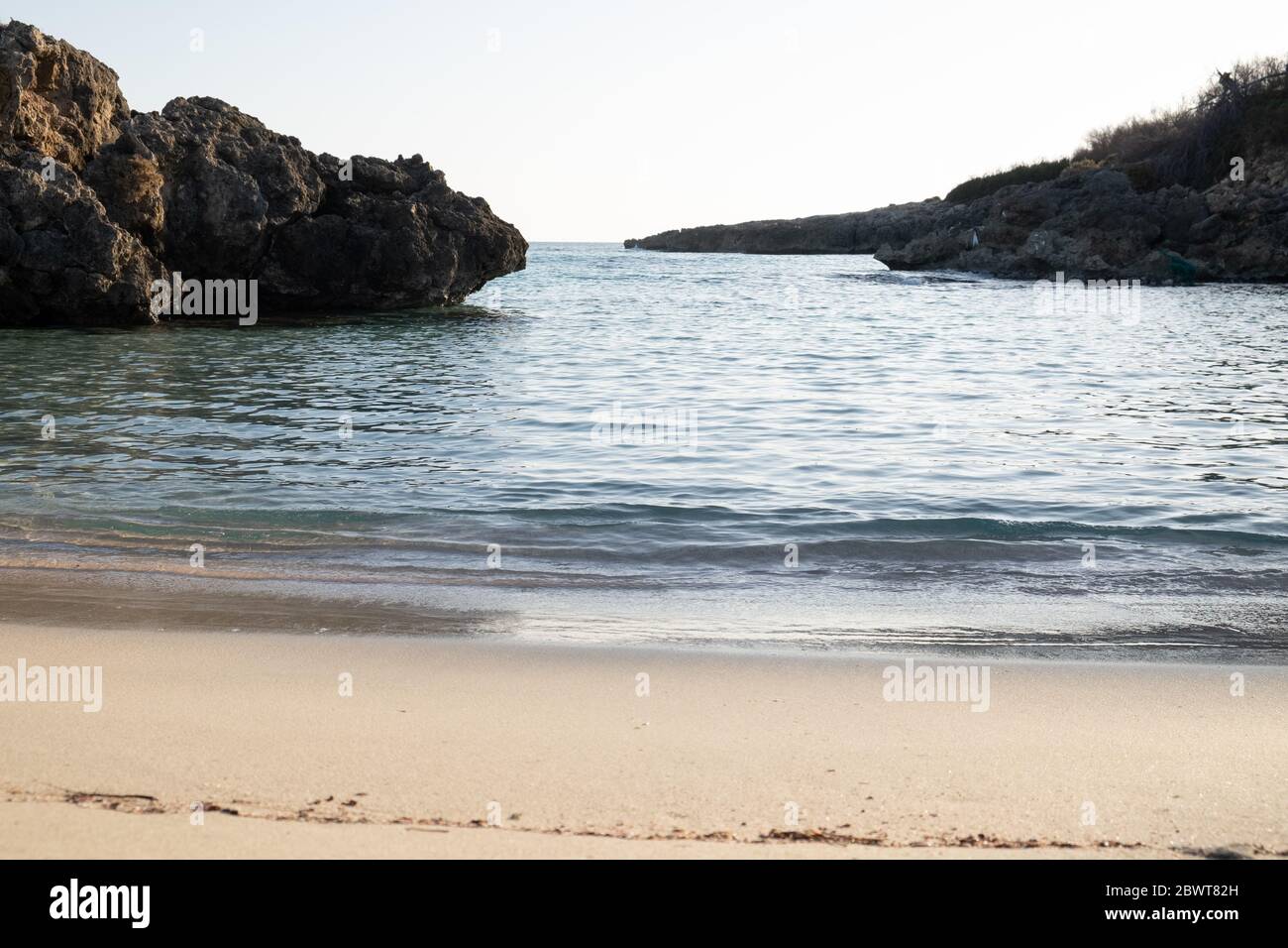 Wir sind an einem Strand in Süditalien in Taranto, das Wasser des jonio-farbigen Torche Meer taucht den feinen Sand der Küste in den Sonnenuntergang Stunden. Stockfoto