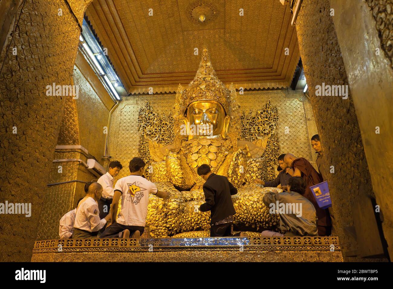 Männliche Anhänger, die goldene Blätter an der Mahamuni Buddha Statue befestigen. Mandalay, Myanmar Stockfoto