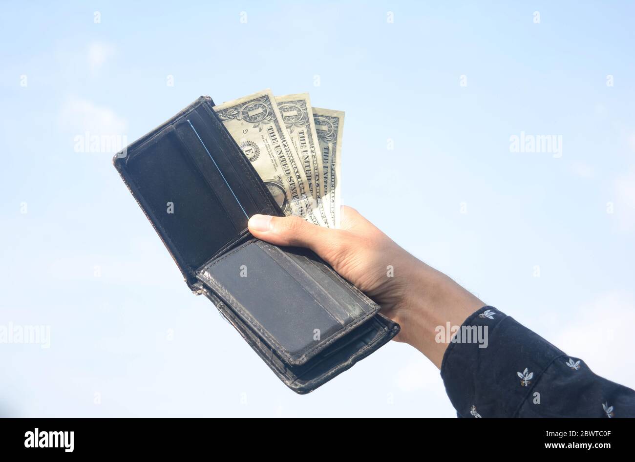 Junger Mann Hände zeigen Dollarscheine . Dollar-Rechnungen auf Himmel Hintergrund. Stockfoto