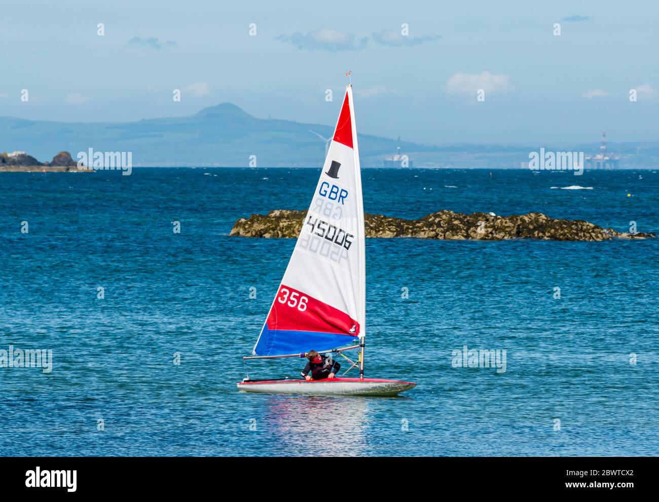 Junge in Segeljolle an sonnigen Tag in Firth of Forth, North Berwick, East Lothian, Schottland, Großbritannien Stockfoto