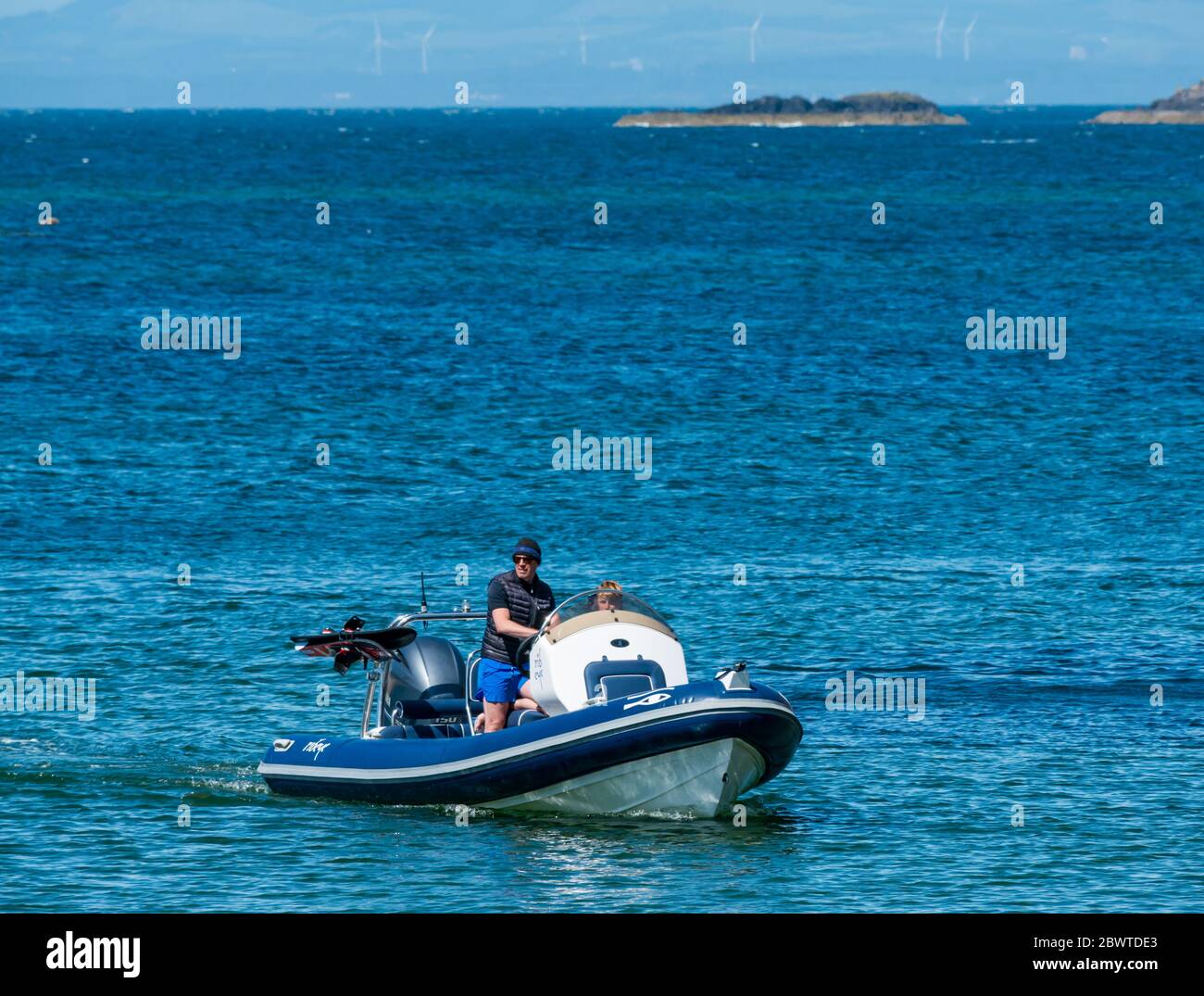 Mann und Junge in einem starren Schlauchboot in Firth of Forth, North Berwick, East Lothian, Schottland, Großbritannien Stockfoto