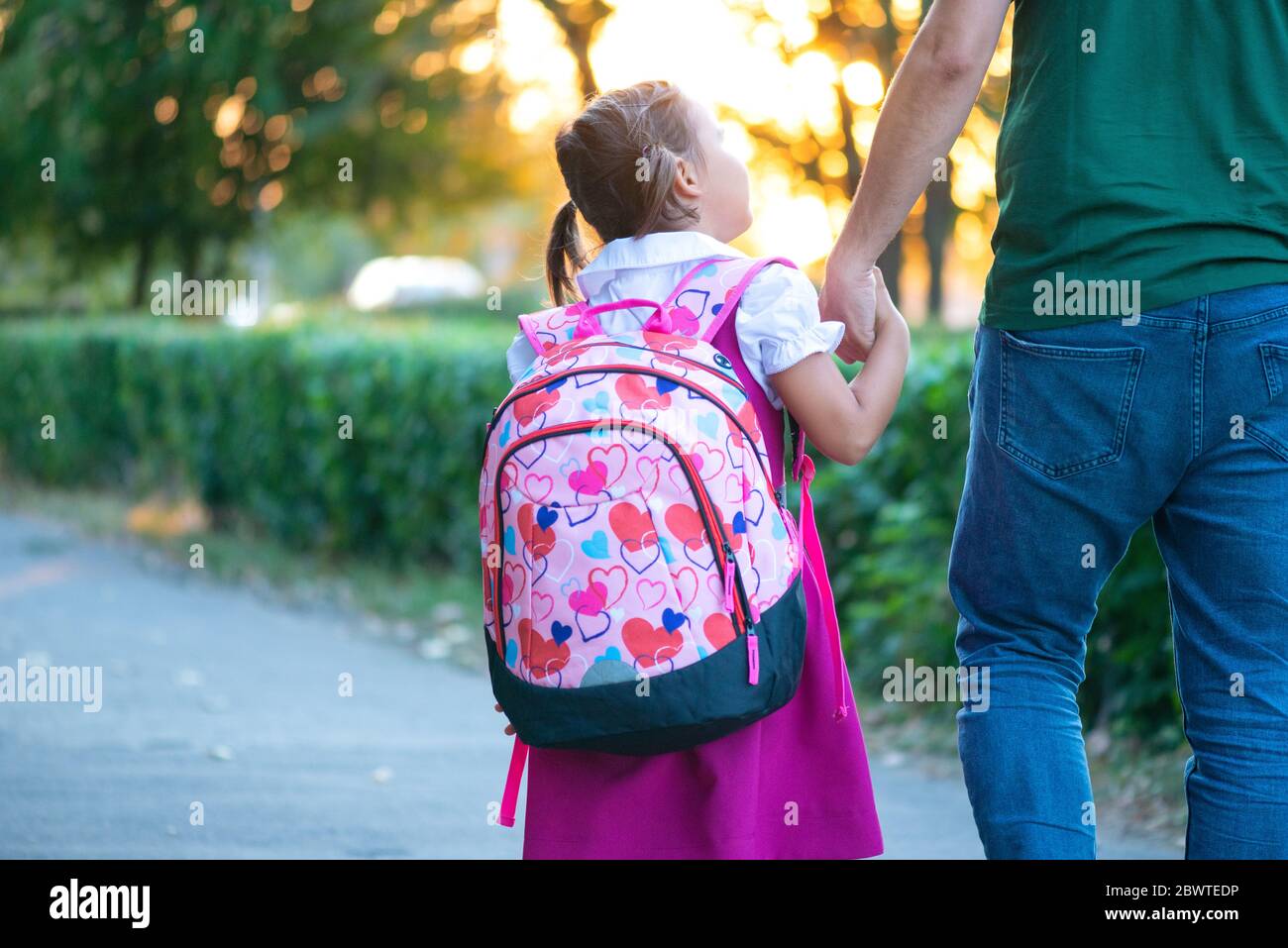 Erster Schultag. Vater führt ein kleines Mädchen in der ersten Klasse Stockfoto