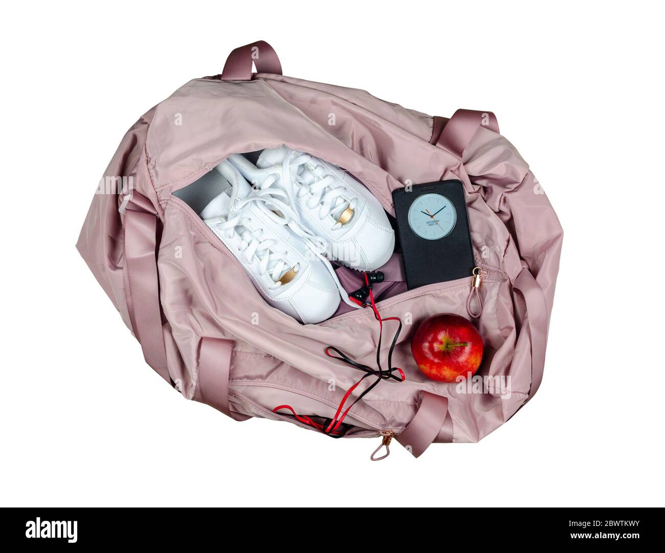 Damen rosa Turnbeutel mit weißen Turnschuhen, roten Apfel und Smartphone zeigt Zeit und Datum, isoliert auf weißem Hintergrund Stockfoto