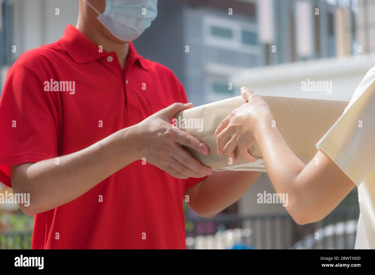 Frau Hand Annahme einer Lieferung von Kisten von Lieferung Mann. Online-Shopping und Expressversand . Quarantäne. Covid-19-Konzept. Stockfoto