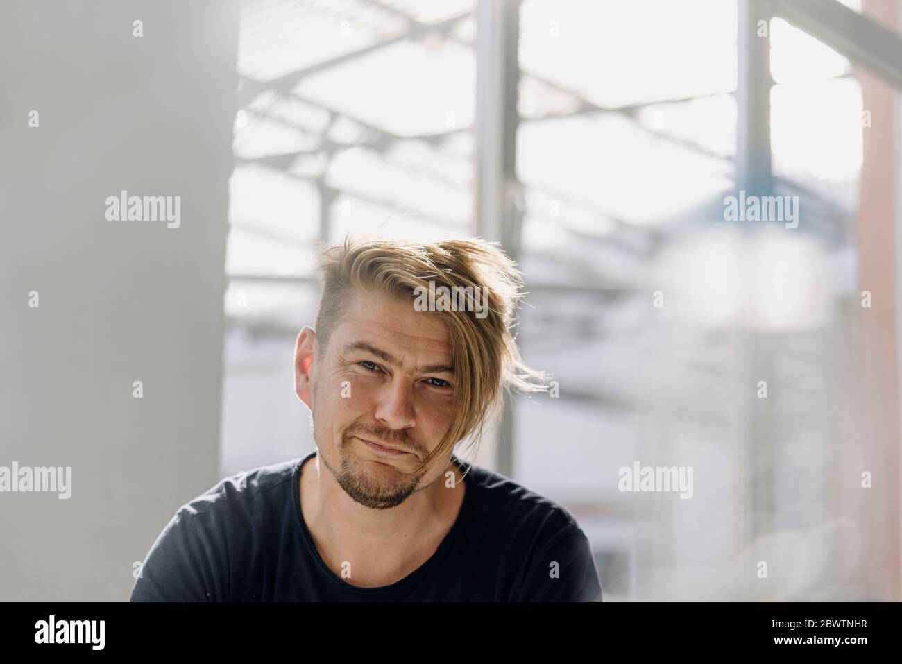 Porträt eines selbstbewussten bärtigen Mannes am Fenster Stockfoto
