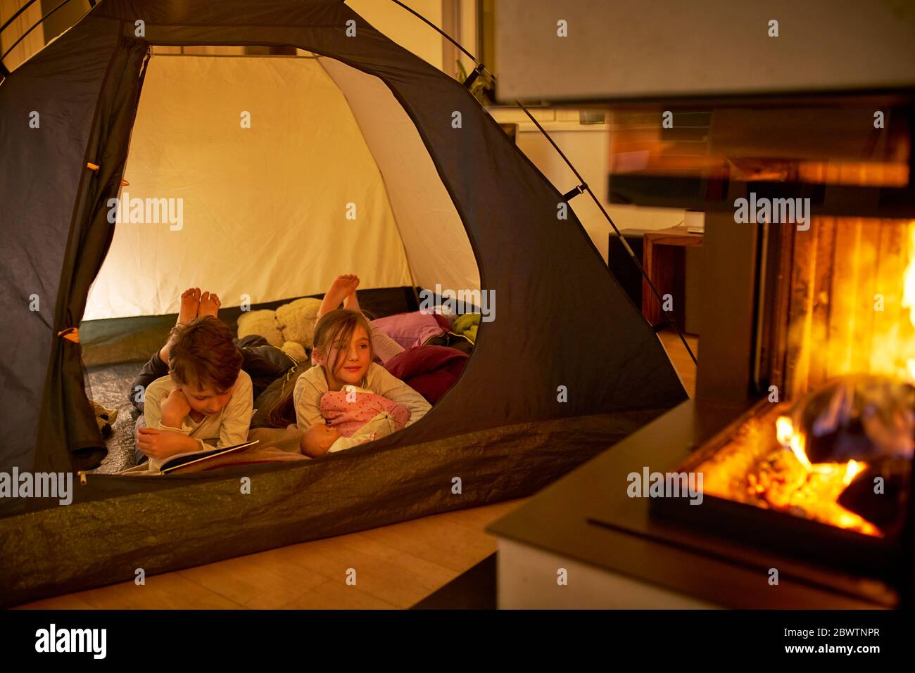 Bruder und Schwester Camping im Wohnzimmer in der Nähe Kamin Stockfoto