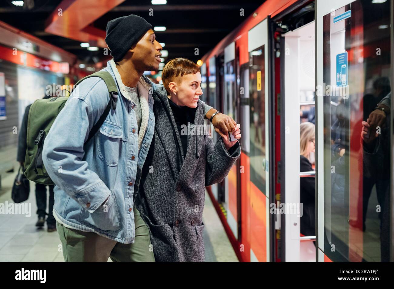 Junges Paar am Bahnsteig, das die U-Bahn betritt Stockfoto
