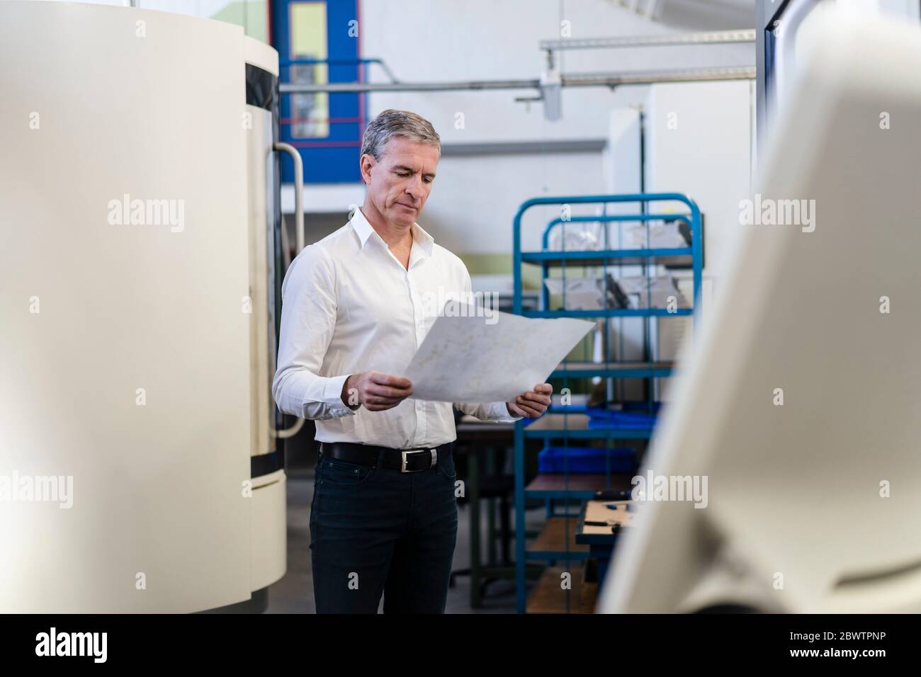 Leitende Angestellte prüft Produktionspläne Stockfoto