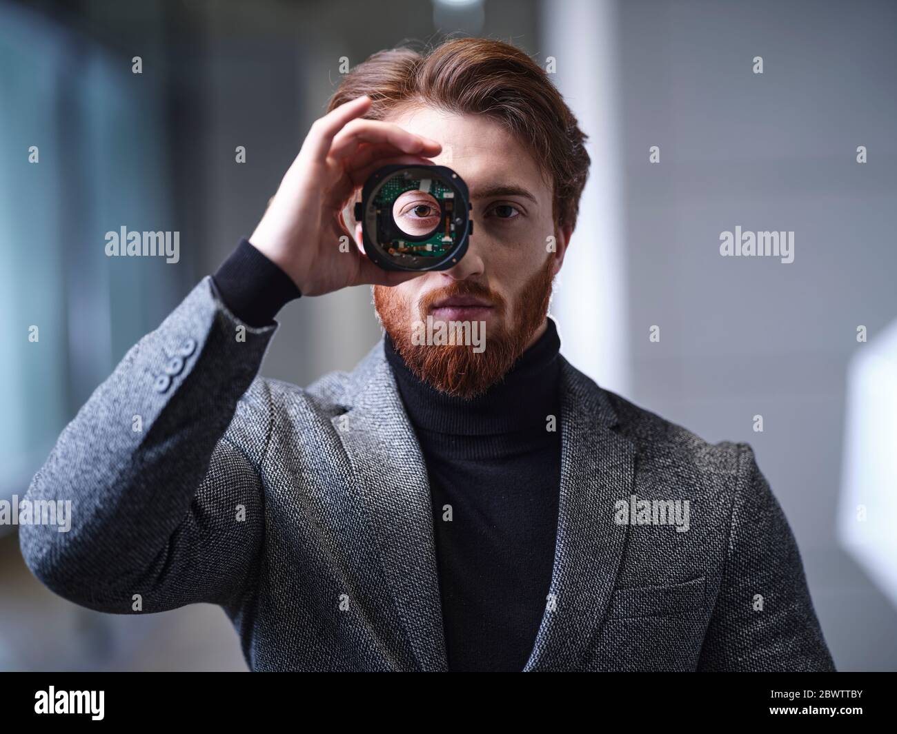 Porträt des Geschäftsmannes Blick durch ein Objekt in modernen Büro Stockfoto