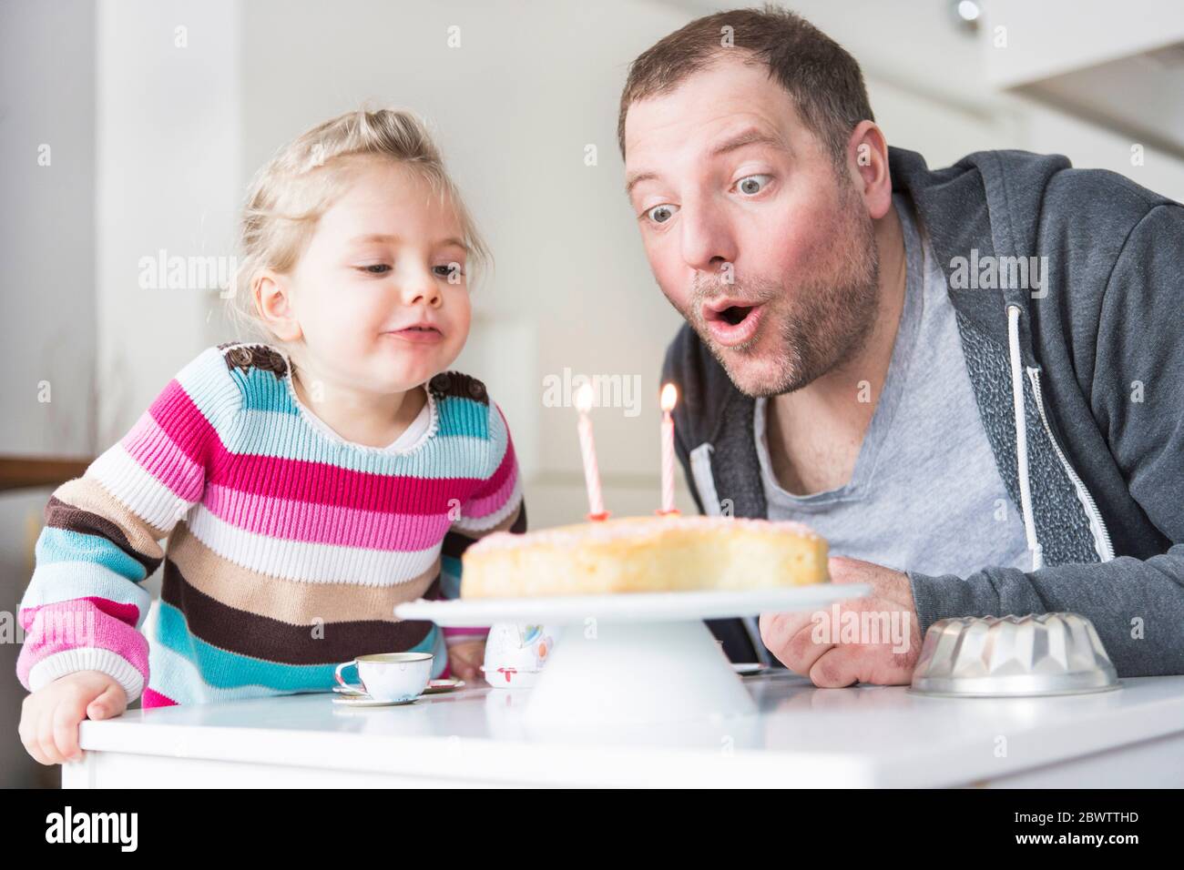 Vater und Tochter Geburtstagskerzen Ausblasen Stockfoto