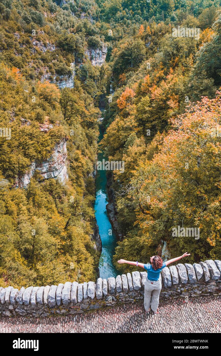 Spanien, Provinz Huesca, Luftaufnahme einer jungen Frau, die mit erhobenen Armen auf einer Steinbrücke steht Stockfoto
