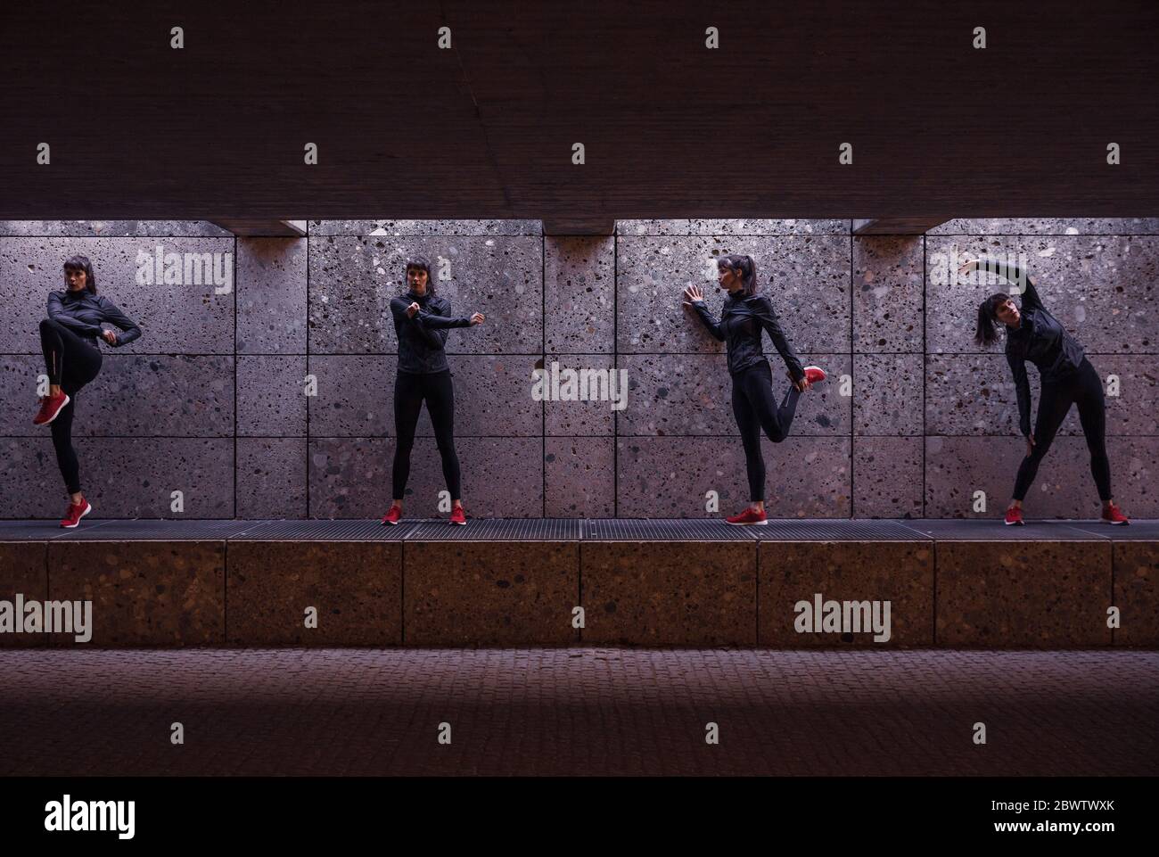 Weibliche Sportlerin, die sich vor dem Laufen in der Fußgängerunterführung aufwärmt Stockfoto