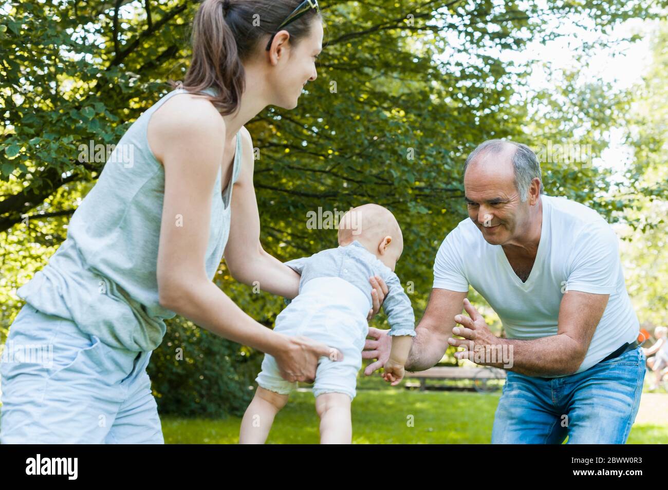 Älterer Mann verbringt Zeit mit seiner erwachsenen Tochter und seiner Enkelin in einem Park Stockfoto