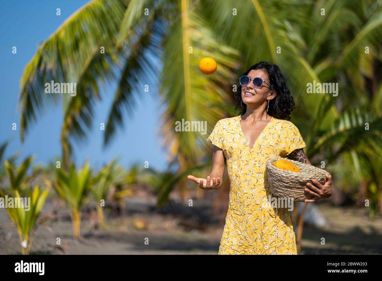 Junge Frau mit Obstkorb am Strand, Costa Rica Stockfoto