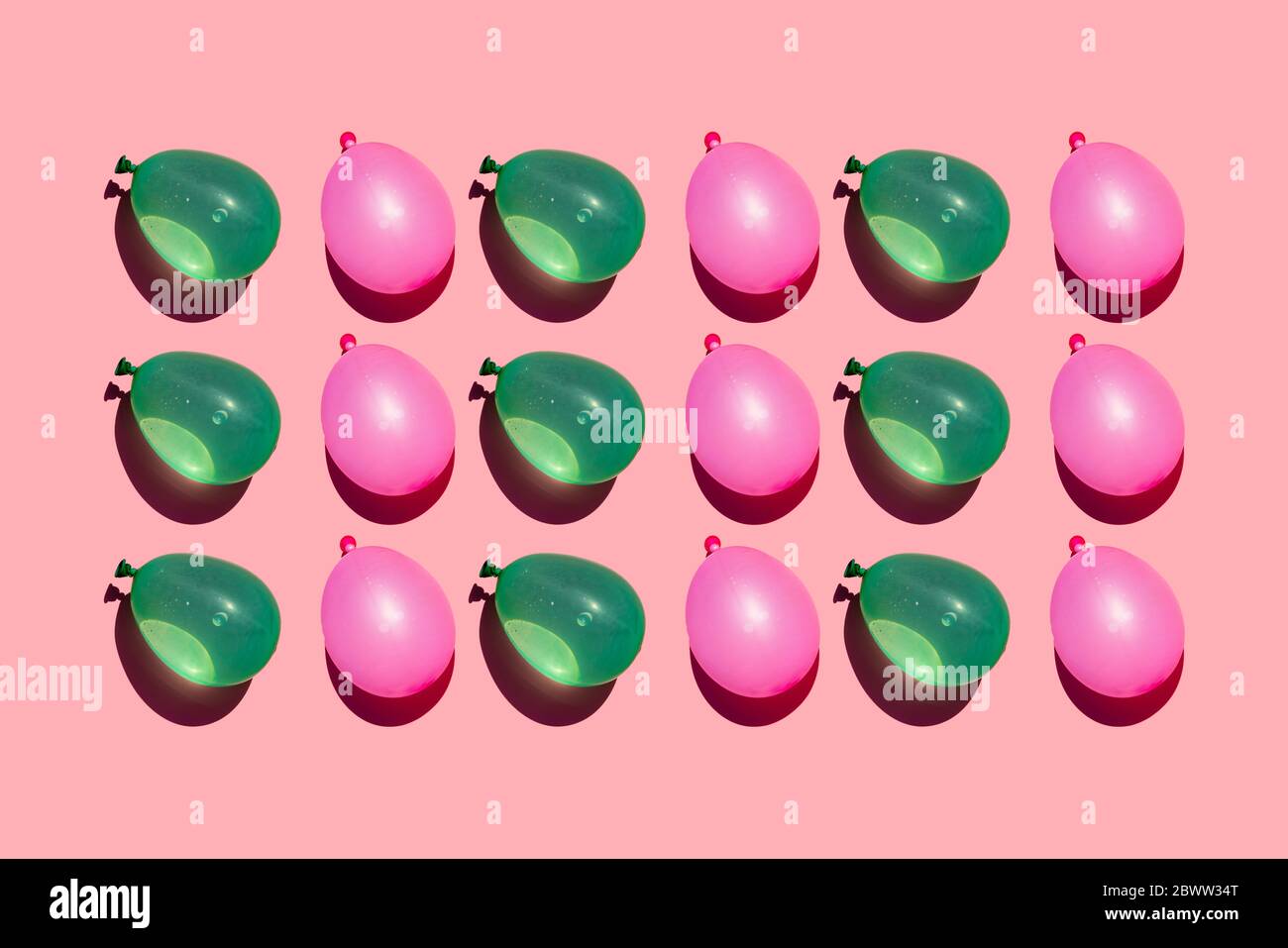 Studio Aufnahme von Reihen von rosa und grünen Wasser Ballons Stockfoto