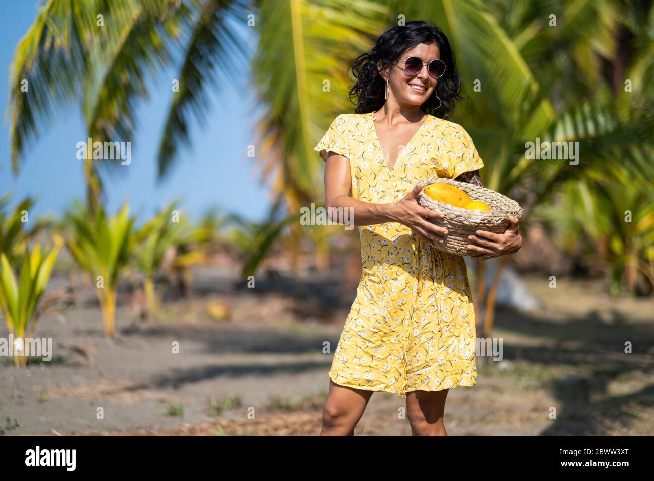 Junge Frau mit Obstkorb am Strand, Costa Rica Stockfoto