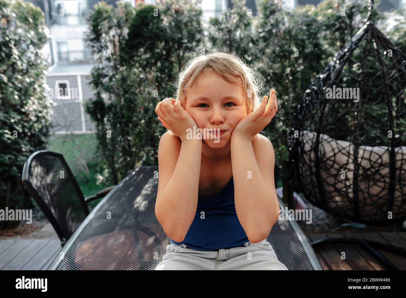 Portrait von blonden Mädchen auf der Terrasse ziehen lustige Gesichter Stockfoto