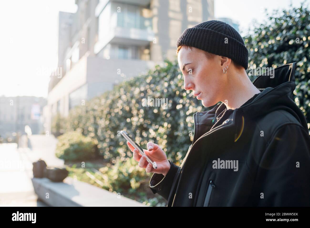 Seriöse junge Frau mit Smartphone in der Stadt Stockfoto