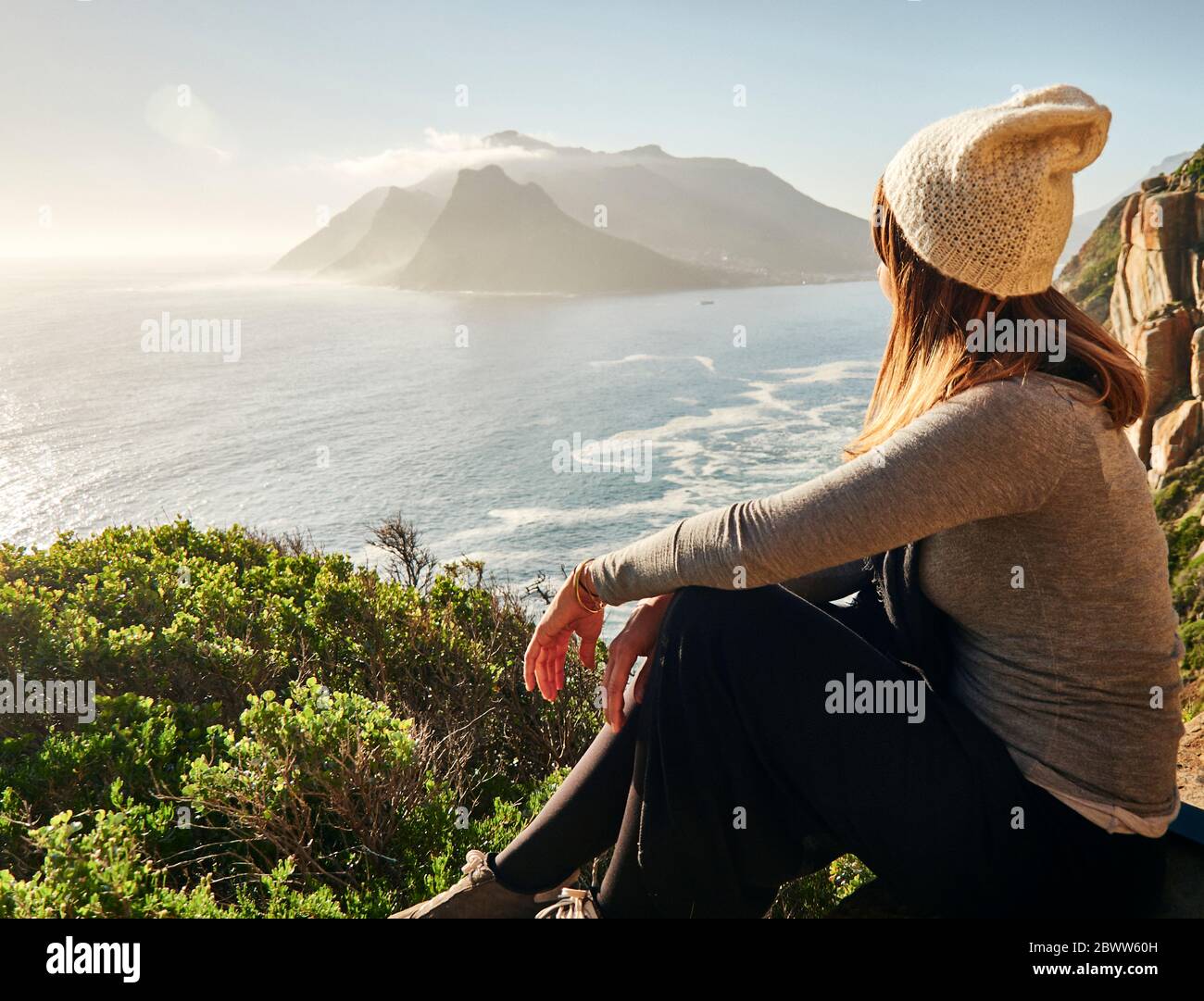 Frau, die die Aussicht von der Spitze eines Berges genießt, Chapman's Peak Drive, Südafrika Stockfoto