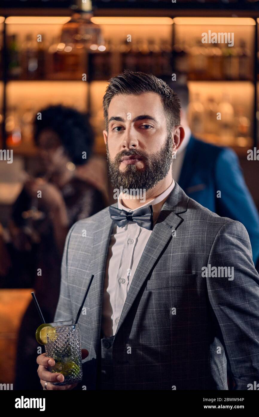 Porträt eines jungen Mannes, der einen Cocktail in einer Bar hat Stockfoto