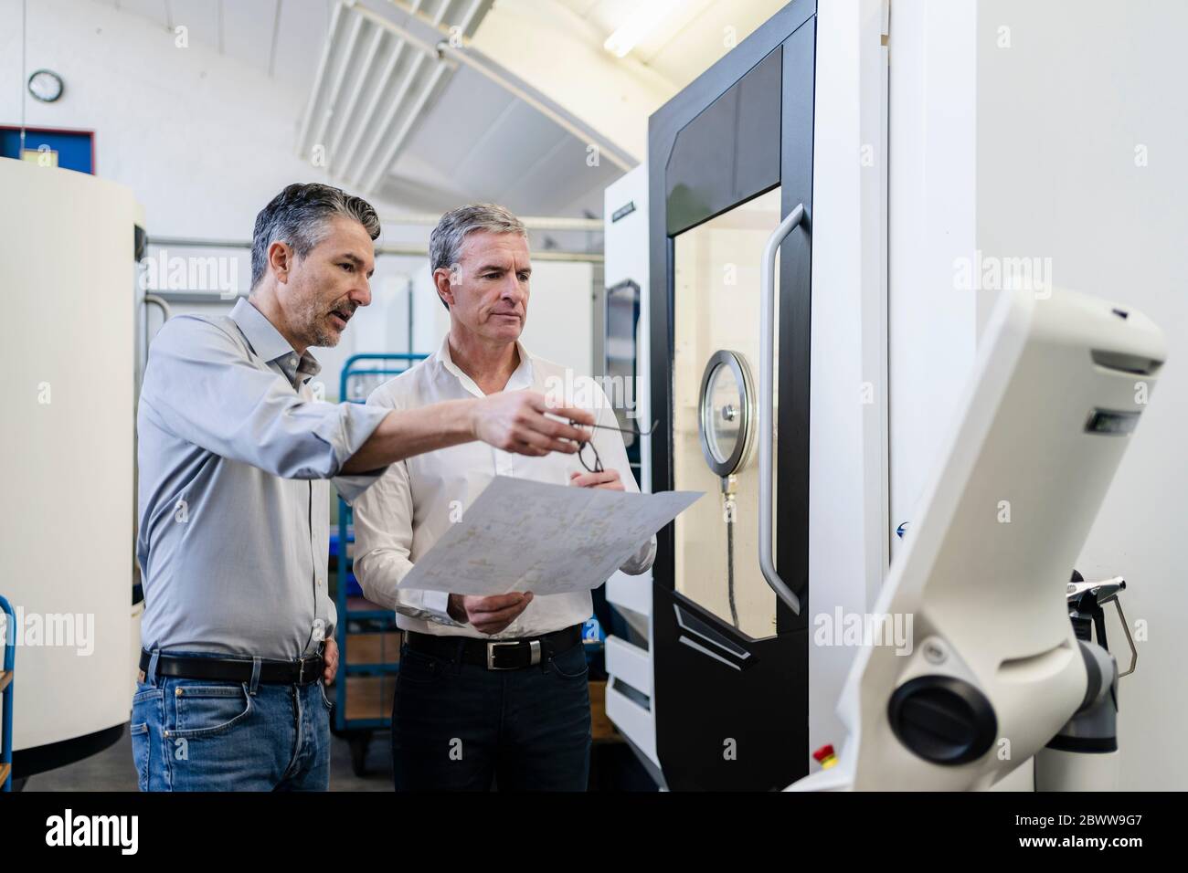 Geschäftsleute in der Fabrik, mit einem Treffen, besprechen Pläne Stockfoto