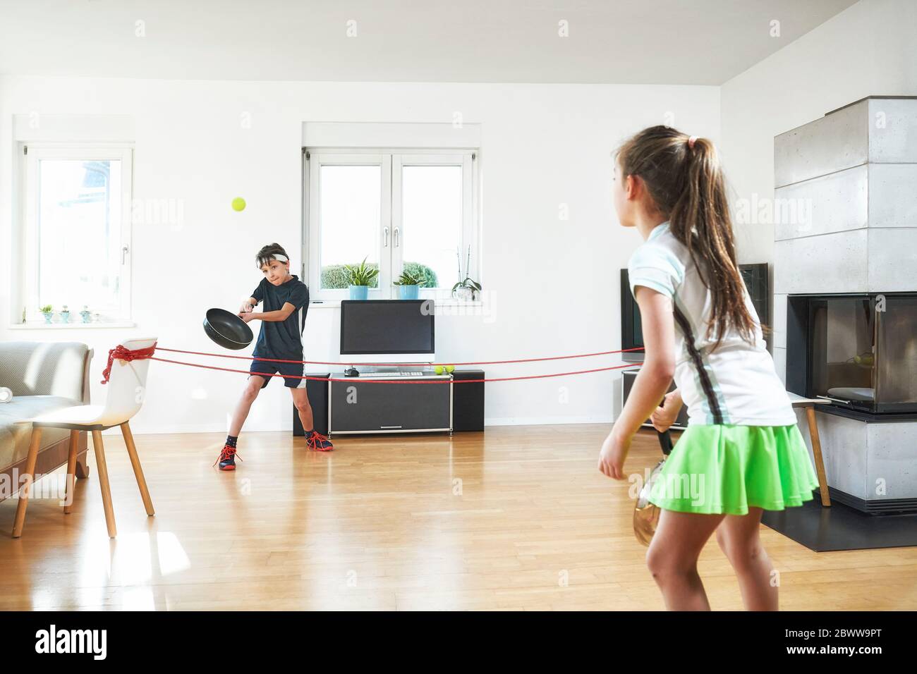 Geschwister genießen Tennis zu Hause während Pandemie-Situation Stockfoto