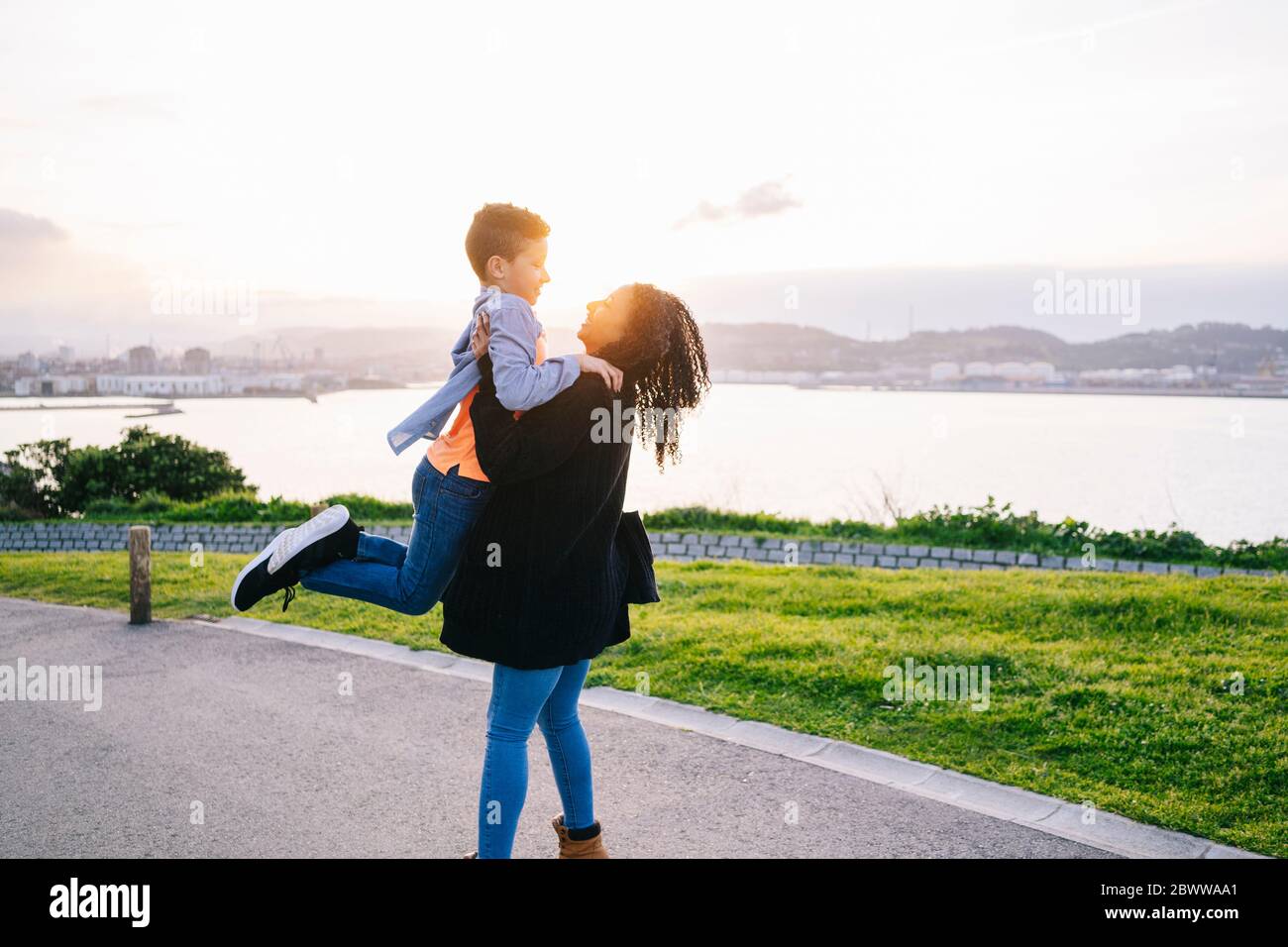 Glückliche junge Mutter verbringt Zeit mit ihrem Sohn am Abend Stockfoto