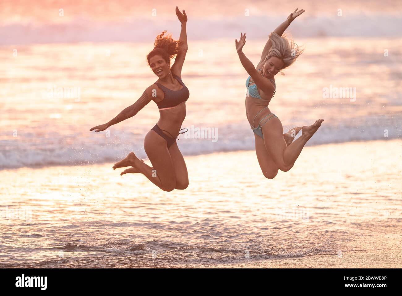 Zwei sorglose Frauen springen am Strand, Costa Rica Stockfoto Zwei sorglose Frauen springen am Strand, Costa Rica Stockfoto