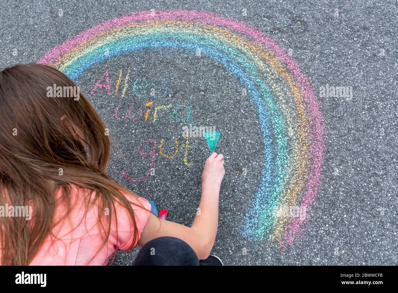 Mädchen malen Regenbogen auf der Straße mit dem Text "alles wird an seinen Platz fallen" Stockfoto