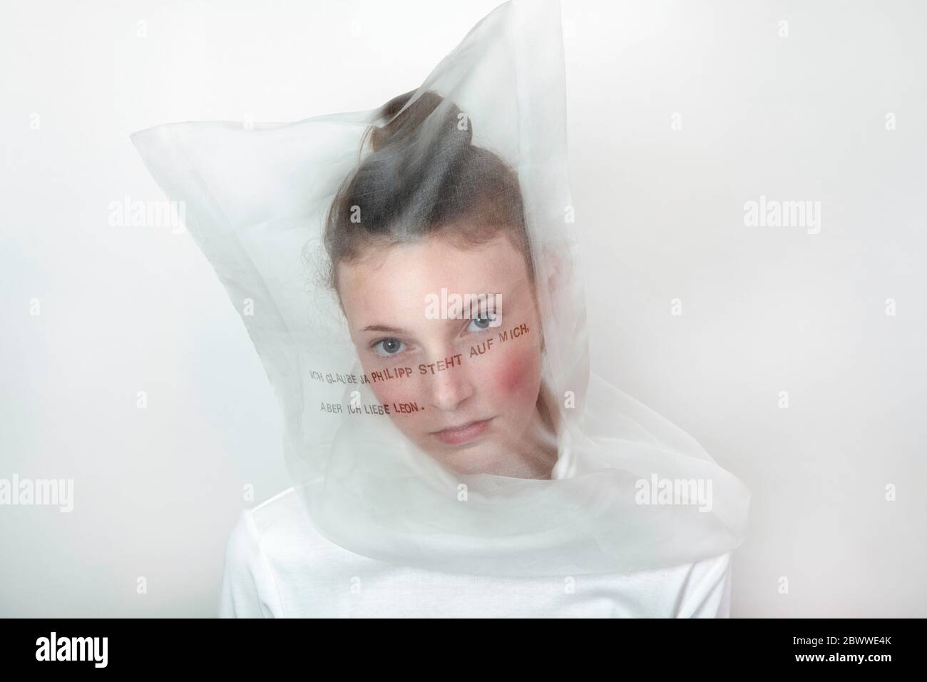Portrait von nachdenklichen Teenager-Mädchen trägt transparente Maske mit Gedanken Stockfoto