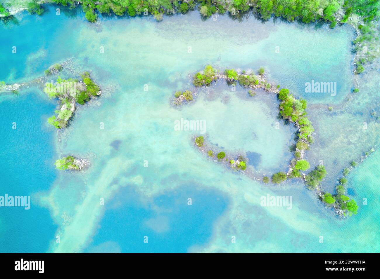 Romantische Küste mit grüner Vegetation und türkisblauem Wasser oben aus der Luft Stockfoto