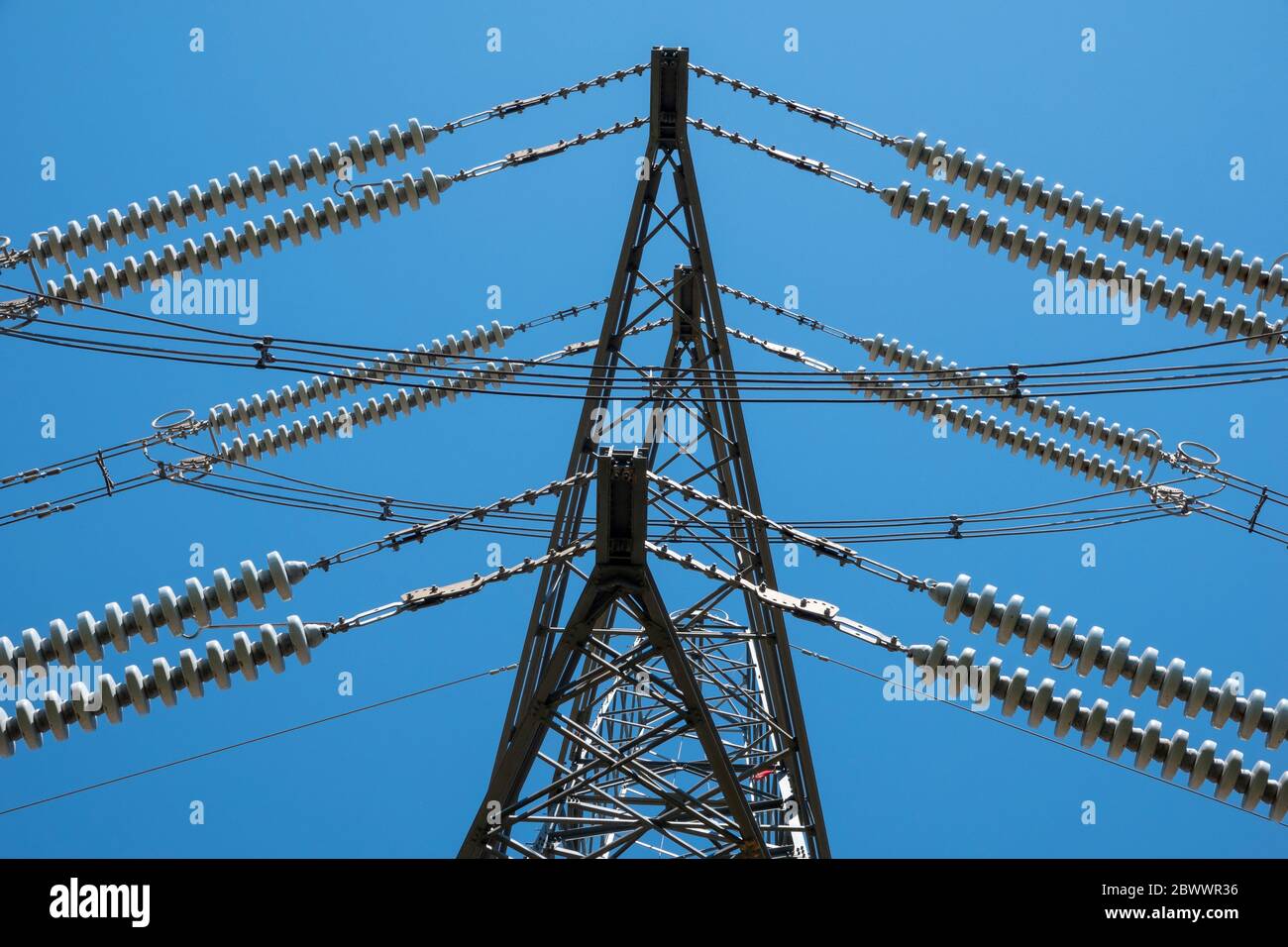 Nahaufnahme von Details von Abschnitten eines Hochspannungsmasten vor einem lebendigen blauen Himmel Stockfoto