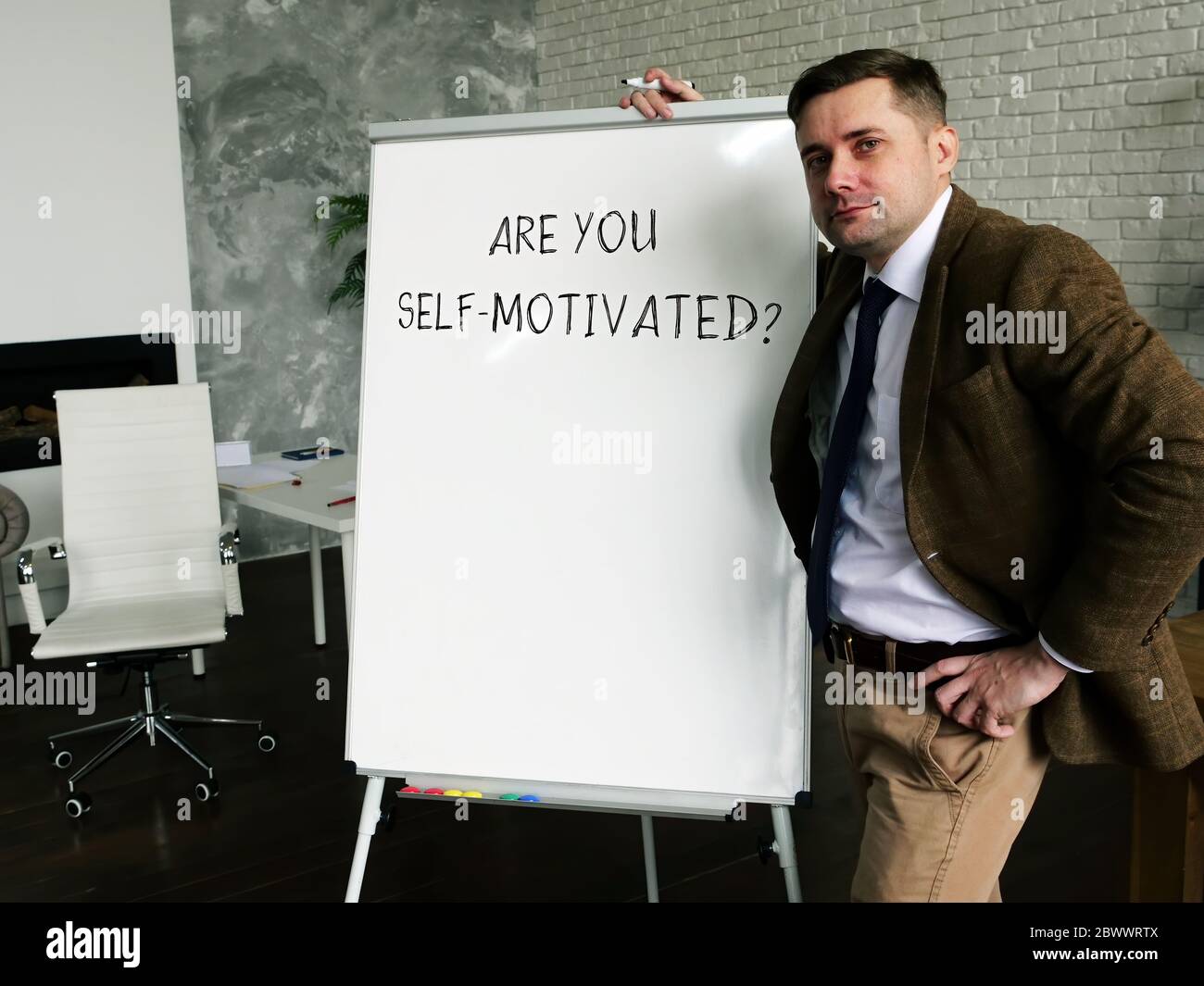 Ein Mann schreibt eine Inschrift sind Sie selbst motiviert? Konzept der Arbeitsmotivation. Stockfoto