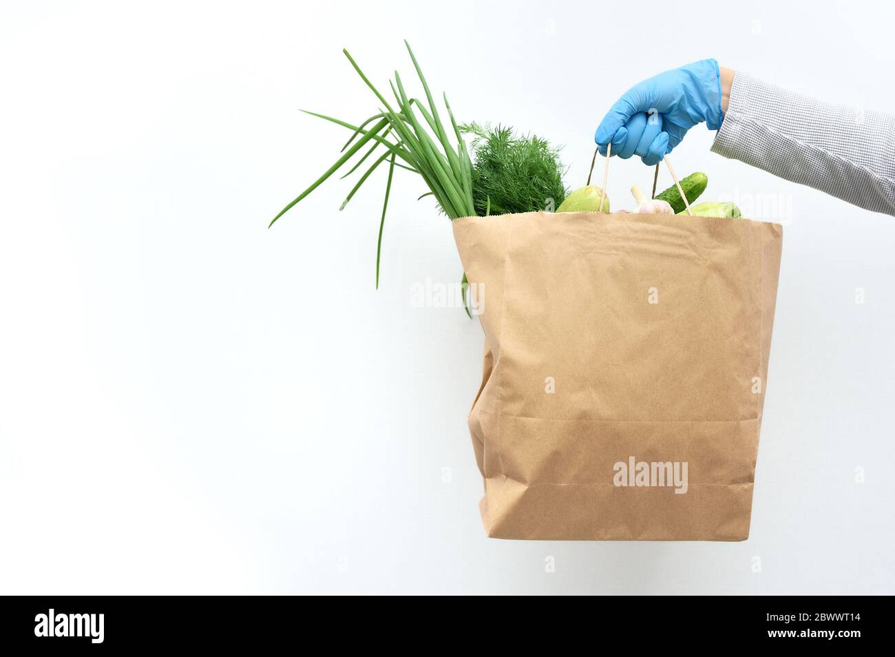 Volunteer in blauen Handschuhen hält Lebensmittel Spende Paket Gemüse, um die Armen zu helfen. Donat-Box mit Lebensmitteln mit Platz für Ihren Text Stockfoto