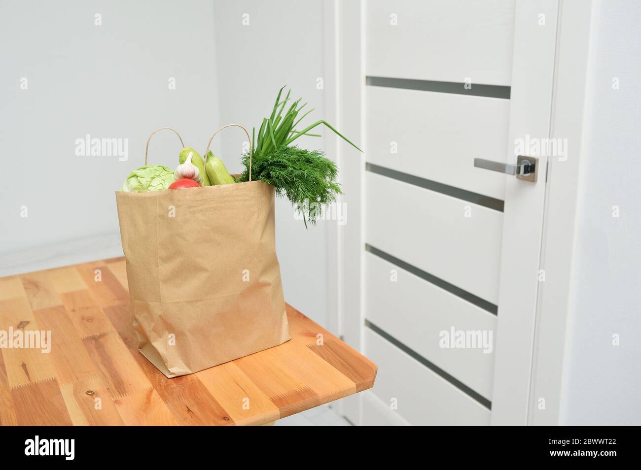 Kontaktlose Produktlieferung an der Tür. Lebensmittel Spende Paket Gemüse, um den Armen zu helfen. Donat-Box mit Lebensmitteln Stockfoto