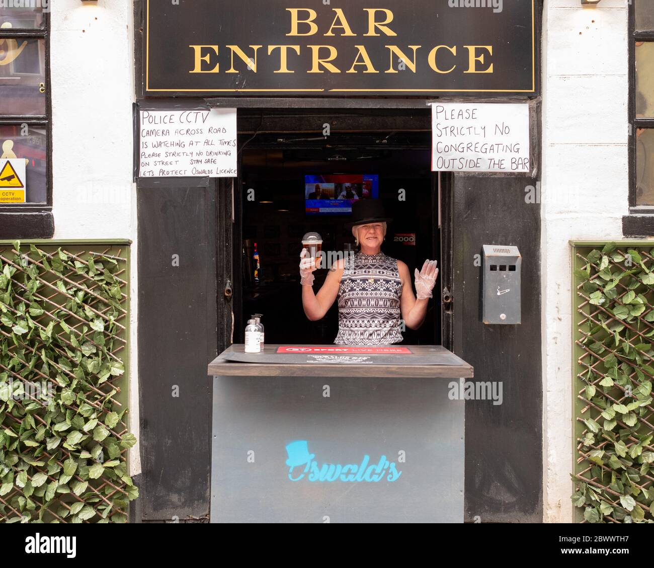 Glasgow, Schottland, Großbritannien. Juni 2020. Oswald's Bar ist beliebt und serviert Gerichte zum Mitnehmen im Stadtzentrum von Glasgow. Die Bar hat eine Take-away Lizenz und Getränke werden in versiegelten Gläsern serviert, die dann weggenommen werden und an der Bar nicht getrunken werden dürfen. Sicherheitskräfte sind vor der Bar, um soziale Distanz zu gewährleisten Kredit: Kay Roxby / Alamy Live News Stockfoto