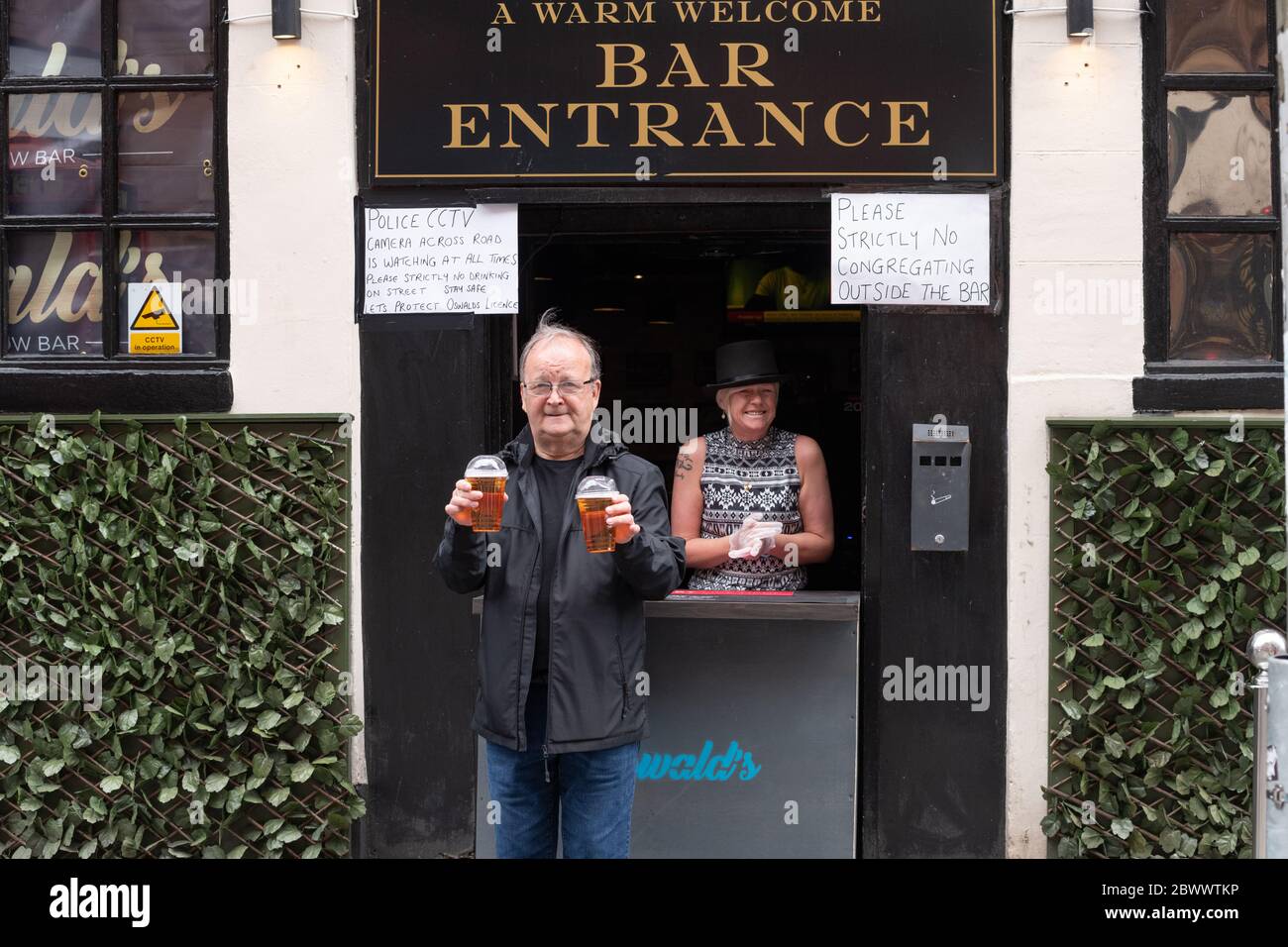 Glasgow, Schottland, Großbritannien. Juni 2020. Oswald's Bar ist beliebt und serviert Gerichte zum Mitnehmen im Stadtzentrum von Glasgow. Die Bar hat eine Take-away Lizenz und Getränke werden in versiegelten Gläsern serviert, die dann weggenommen werden und an der Bar nicht getrunken werden dürfen. Sicherheitskräfte sind vor der Bar, um soziale Distanz zu gewährleisten Kredit: Kay Roxby / Alamy Live News Stockfoto