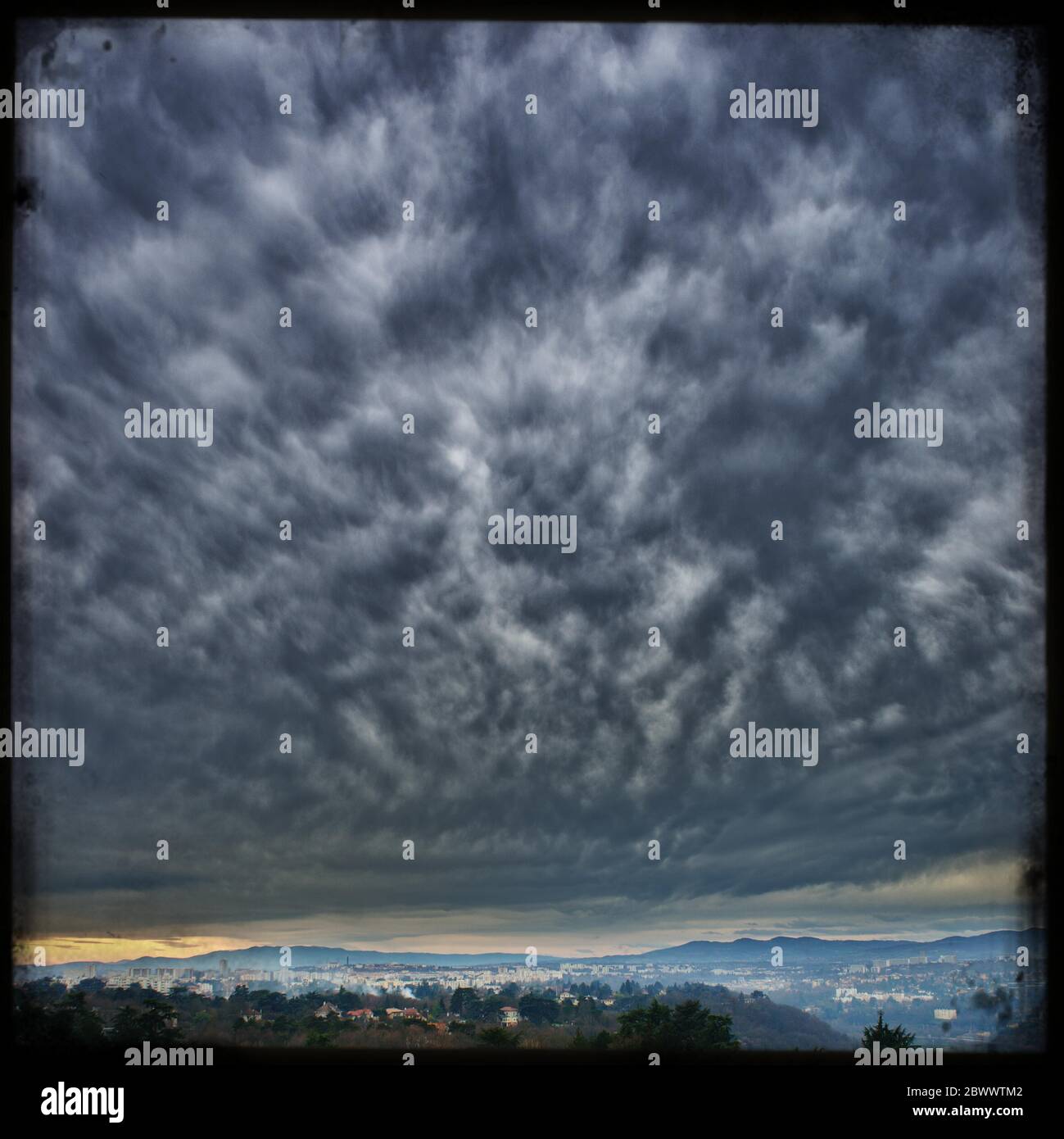 Dramatischer wolkiger Himmel über der Stadt Clermont-Ferrand, Retro-Foto, Argentique Stockfoto