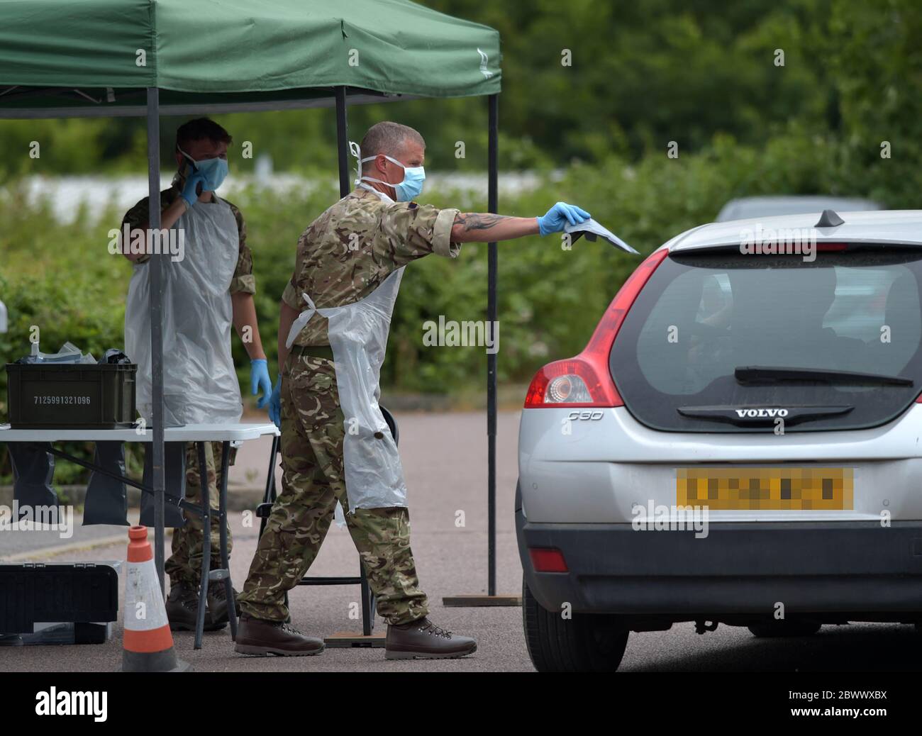 Ein Reservist des Royal Anglian Regiment übergibt dem Insassen eines Fahrzeugs im Harlow Football Club, Harlow, ein Coronavirus-Selbsttest-Paket, nachdem Maßnahmen eingeführt wurden, um England aus der Sperre zu bringen. Stockfoto