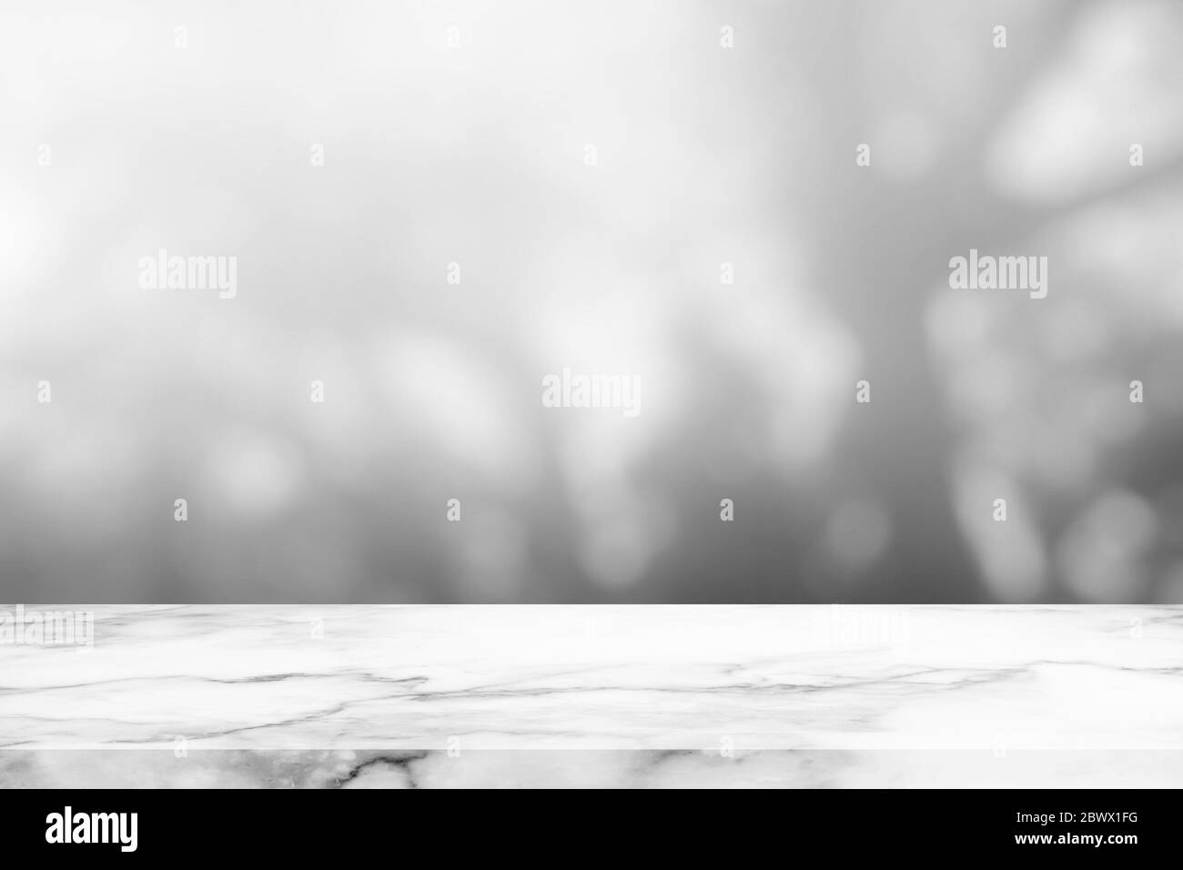Marmortisch mit weißem verschwommenem Bokeh im Garten Hintergrund. Stockfoto