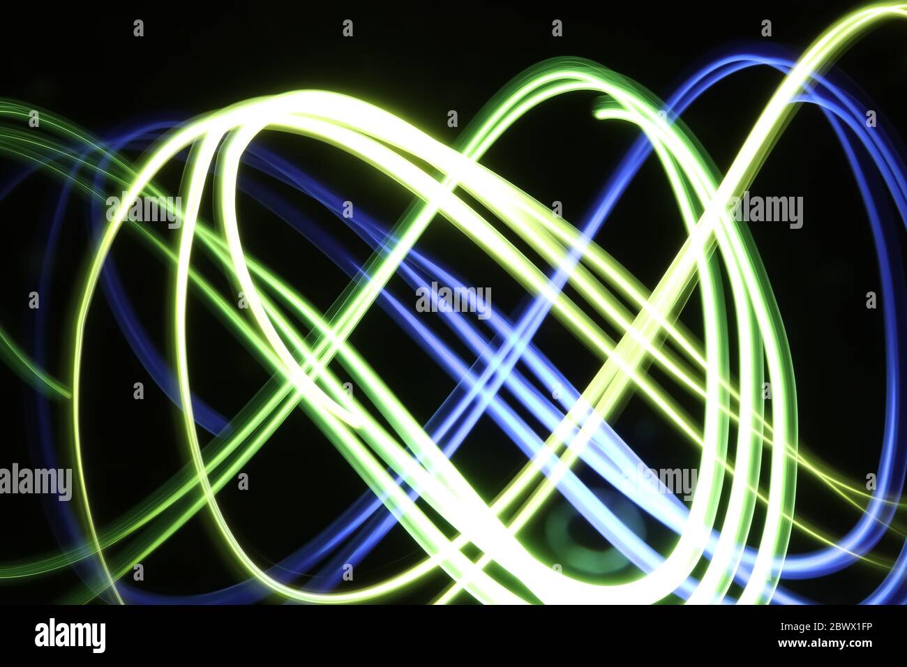 Blau, gelb und grün Licht Malerei Fotografie bilden drei ineinandergreifende Infinity-Symbol-Schleifen mit Wirbeln, Wellen vor einem schwarzen Hintergrund. Stockfoto