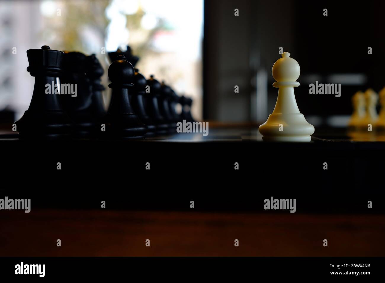 Weißer Bauer gegen die schwarzen Stücke. Stockfoto