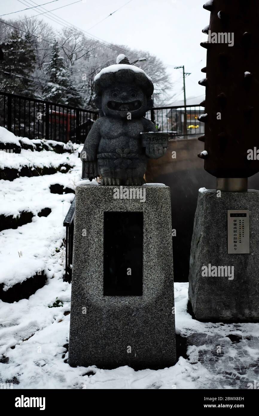 NOBORIBETSU, JAPAN - 15. NOVEMBER 2019: Kleine niedliche japanische Dämonenstatue im Sengenpark am dunklen Wintertag. Es ist ein Symbol des Höllental, Hokkai Stockfoto