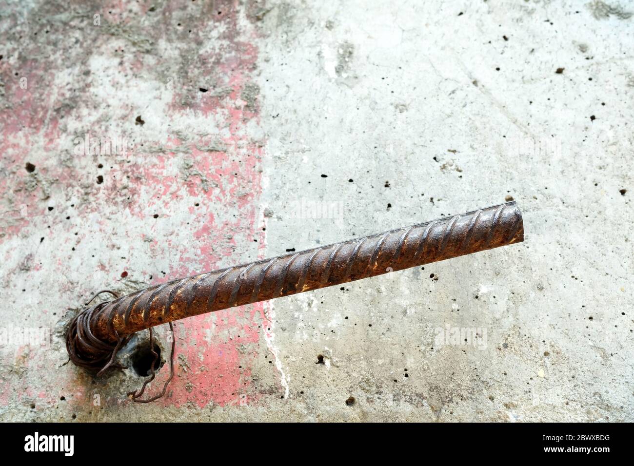 Aus Betonwand herausragende Stahlstange. Stockfoto
