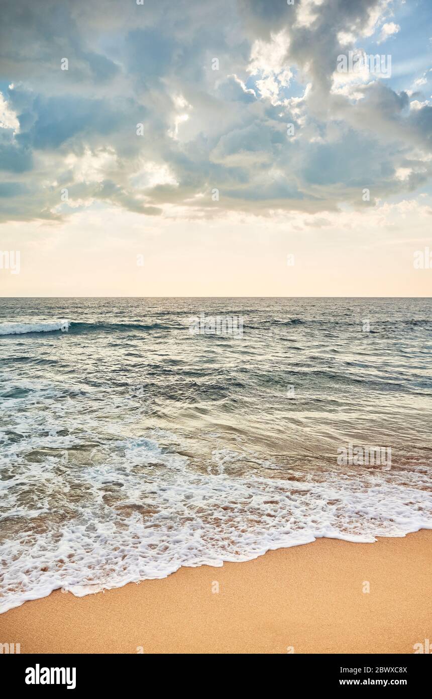 Tropischer Strand mit Horizont über dem Meerwasser bei Sonnenuntergang. Stockfoto