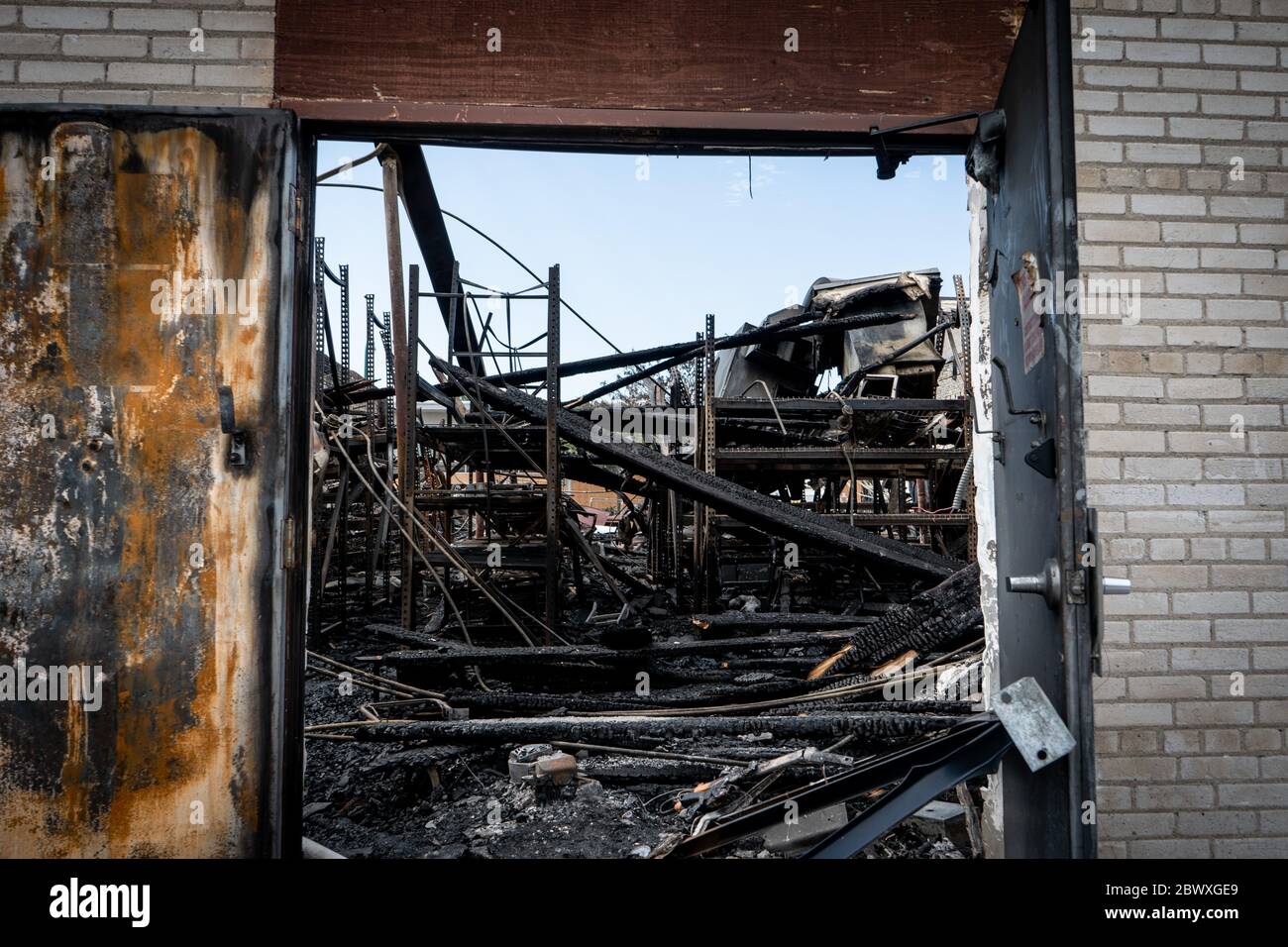 Minneapolis, Minnesota / USA - 2. Juni 2020: Abgebrannte Wirtschaftsgebäude Wrack durch gebrochene Tür am Morgen nach Plünderungen und minneapolis Stockfoto