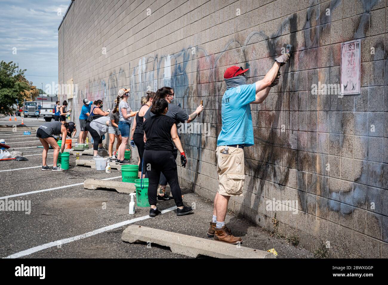 Minneapolis, Minnesota / USA - 2. Juni 2020: Gute Samariter freiwillig, um Graffiti und Müll der lokalen Schule am Morgen nach Plünderungen und zu reinigen Stockfoto